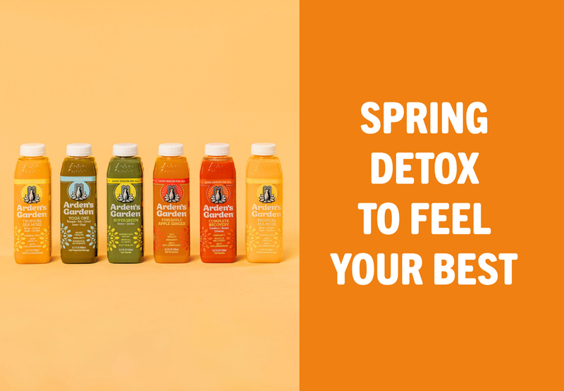 Fresh green cold-pressed juice surrounded by spring vegetables and fruits for a spring detox
